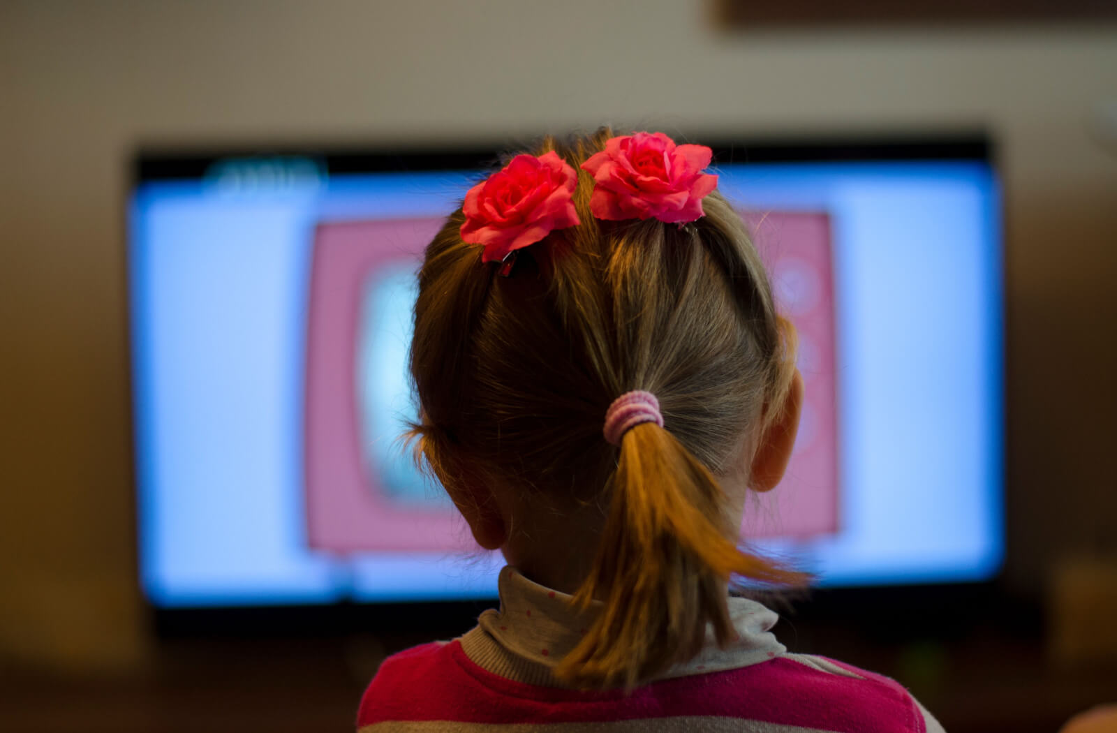 A young girl sitting close to the television screen at home watching cartoons is a sign of myopia. Myopia control glasses can help correct myopia.